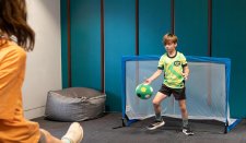 Children playing indoor soccer in front of a goal Children playing indoor soccer in front of a goal
