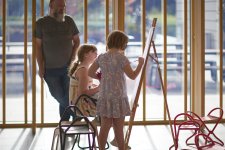 Two children drawing at an easel in the Gordon Darling Hall