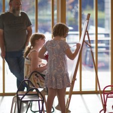 Two children drawing at an easel in the Gordon Darling Hall