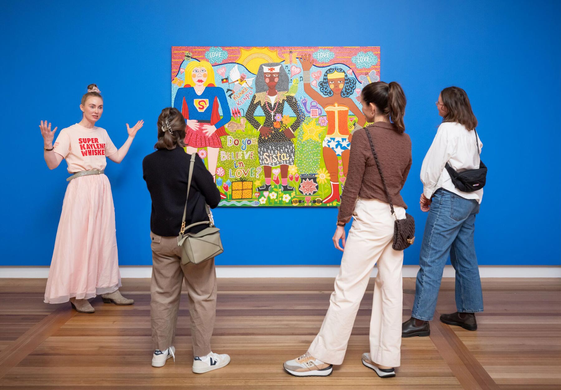 A group of people looking at Do you Believe in Love? 2025 by Kaylene Whiskey