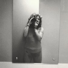 3/4 length self portrait in bathroom mirror, wearing t-shirt, 1979 Carol Jerrems