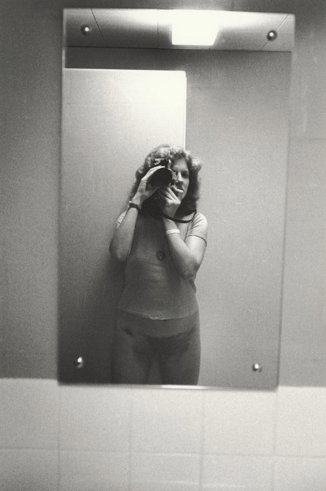 3/4 length self portrait in bathroom mirror, wearing t-shirt, 1979