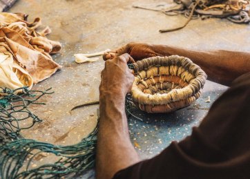 Anindilyakwa artist Maicie Lalara weaving baskets with ghost nets and pandanus, 2019