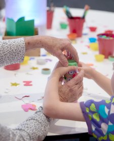 Grandparents and children at a table with craft activities Grandparents and children at a table with craft activities