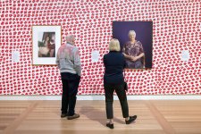 Two people viewing artworks in the In Bloom exhibition