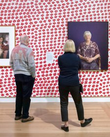 Two people viewing artworks in the In Bloom exhibition