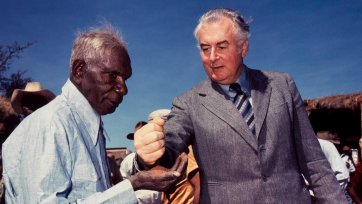 Prime Minister Gough Whitlam pours soil into the hand of traditional land owner Vincent Lingiari