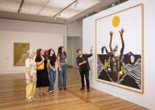 People looking at an artwork (Marcia Langton by Brook Andrew) in the Gallery