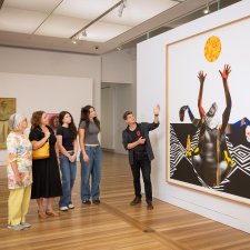 People looking at an artwork (Marcia Langton by Brook Andrew) in the Gallery