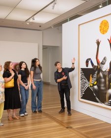 People looking at an artwork (Marcia Langton by Brook Andrew) in the Gallery