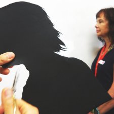 Cutting out a paper silhouette in the shape of a head