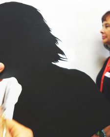 Cutting out a paper silhouette in the shape of a head